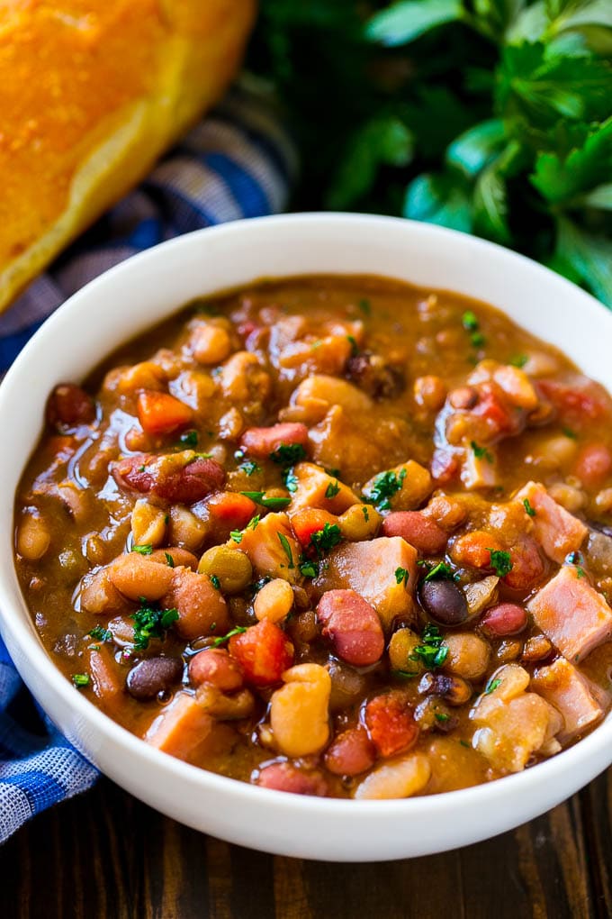 Slow Cooker Ham Bone Soup | Ham and Bean Soup | Ham Bone and Bean Soup | Ham Soup | Leftover Ham Recipe #ham #hamsoup #leftoverham #soup #slowcooker #crockpot #ezlod Crock pot ham bone soup in a bowl topped with parsley.