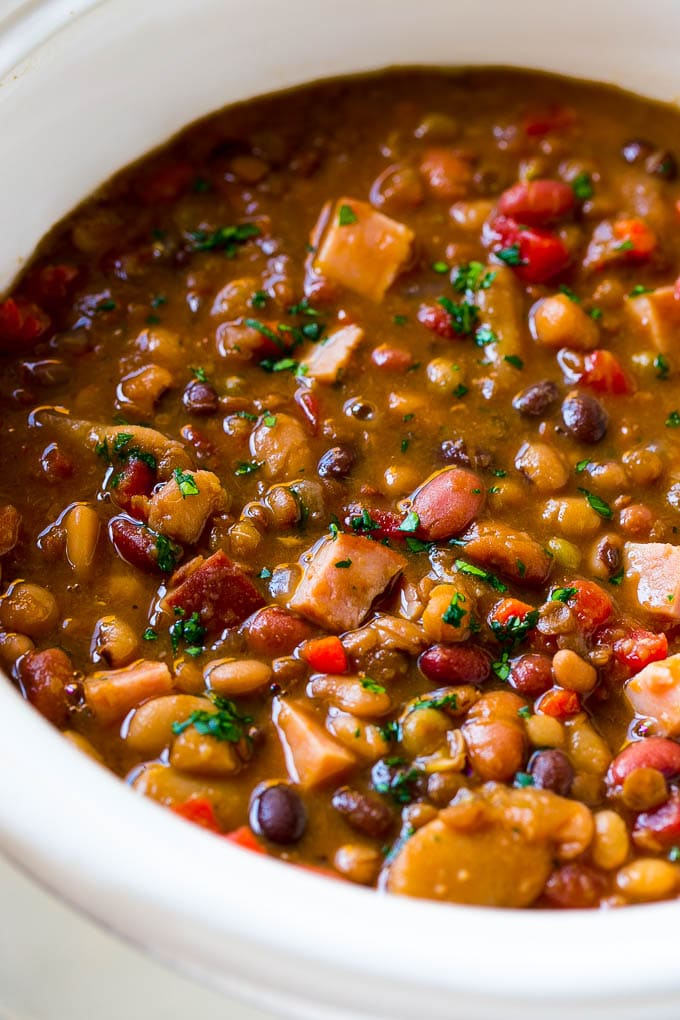 Slow Cooker Ham Bone Soup | Ham and Bean Soup | Ham Bone and Bean Soup | Ham Soup | Leftover Ham Recipe #ham #hamsoup #leftoverham #soup #slowcooker #crockpot #ezlod A slow cooker full of soup with parsley on top.
