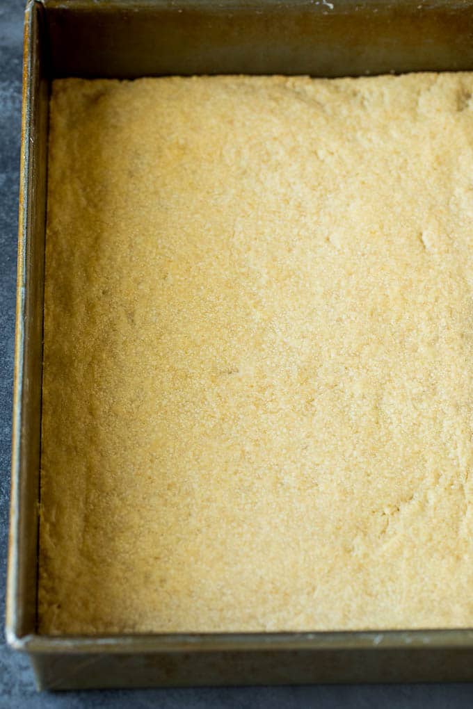 Pecan Pie Bars Recipe #pecans #pie #fall #pecanpie #dessert #thanksgiving #ezlod A shortbread crust in a baking pan.