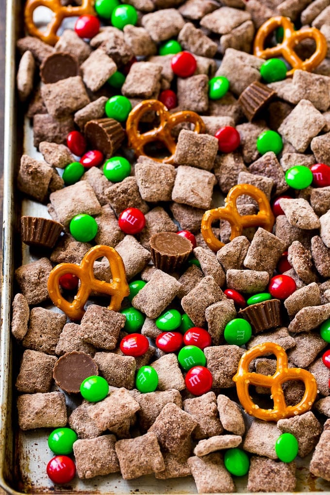 Reindeer Chow | Christmas Chex Mix | Christmas Muddy Buddies | Holiday Chex Mix #chex #chexmix #christmas #holiday #muddybuddies #reindeerchow #snack #ezlod A sheet pan of Christmas muddy buddies mixed with candy and peanut butter cups.