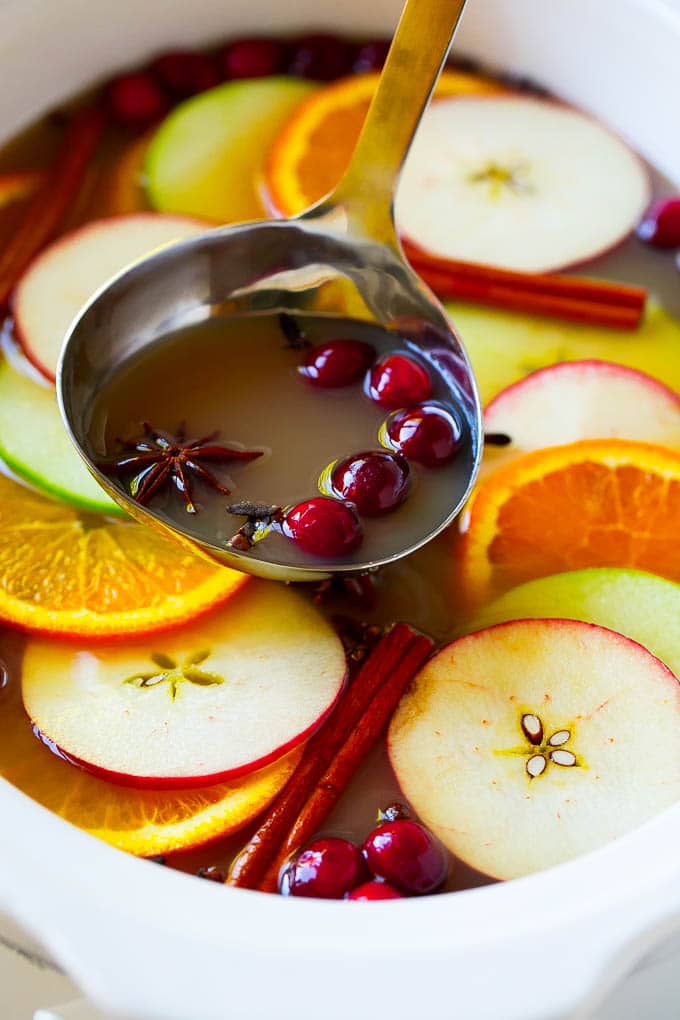 Slow Cooker Apple Cider | Mulled Apple Cider | Crockpot Apple Cider #cider #apple #applecider #drink #crockpot #slowcooker #ezlod A ladle scooping out some warm mulled drink.