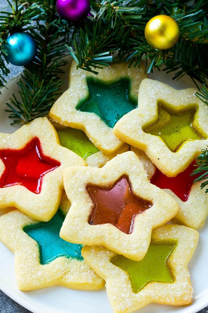 Stained Glass Cookies | Stained Glass Window Cookies | Christmas Cookies | Sugar Cookies | Holiday Cookies #cookies #stainedglasscookies #sugarcookies #christmascookies #christmas #holiday #dessert #ezlod A plate of star shaped stained glass cookies with colorful centers.