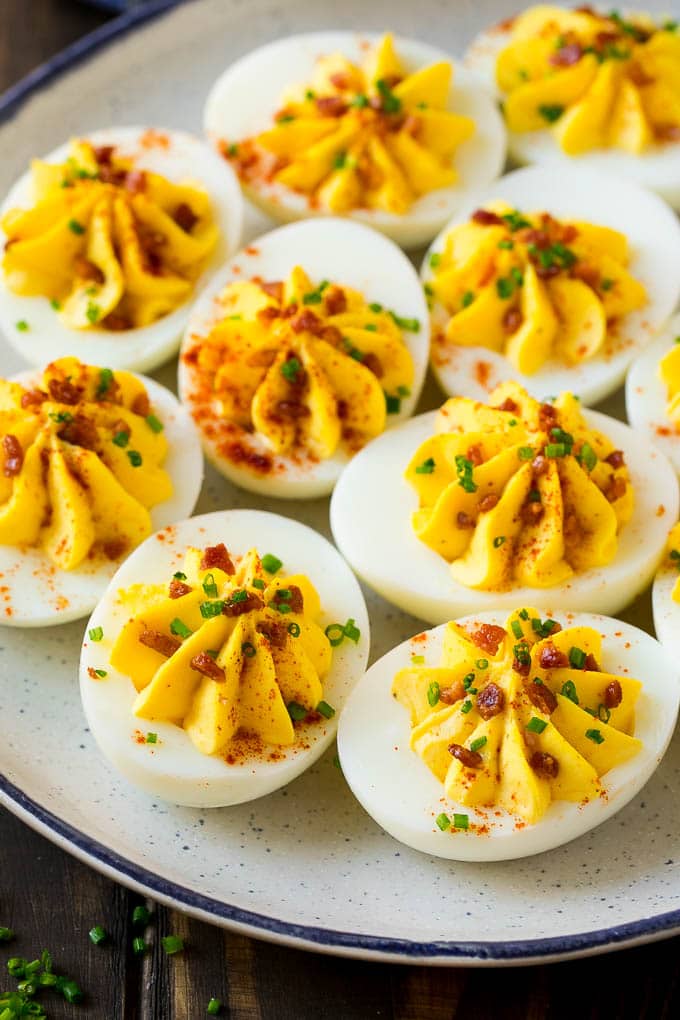 Bacon Deviled Eggs | Deviled Eggs Recipe #eggs #keto #lowcarb #bacon #appetizer #ezlod A plate of bacon deviled eggs garnished with sliced chives and smoked paprika.