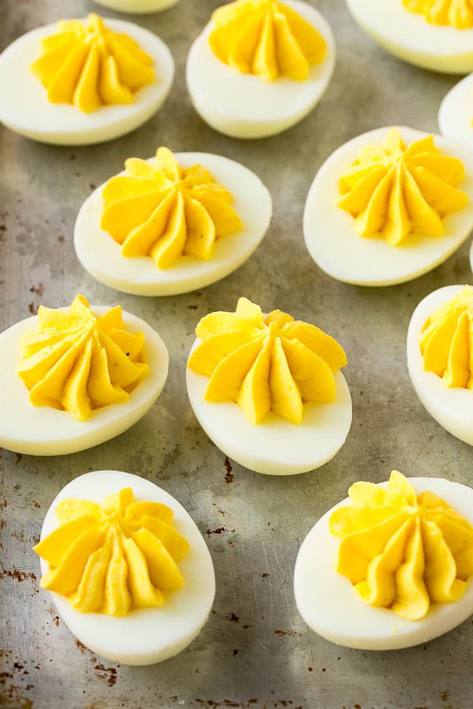 Bacon Deviled Eggs | Deviled Eggs Recipe #eggs #keto #lowcarb #bacon #appetizer #ezlod Deviled eggs with a decoratively piped filling on a sheet pan.