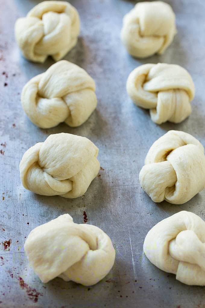 Garlic Knots Recipe | Garlic Rolls | Garlic Butter Rolls | Garlic Bread Recipe #garlic #garlicbread #garlicknots #breadsticks #ezlod Pizza dough tied up and placed on a sheet pan.