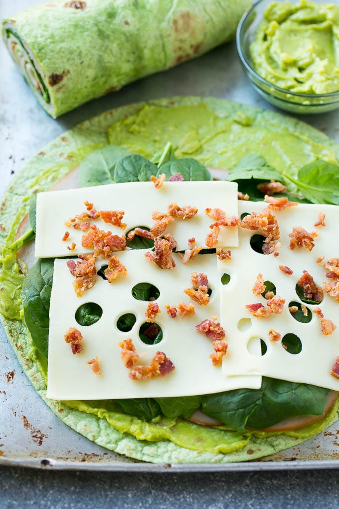 Turkey Roll Ups Recipe | Turkey Pinwheel Sandwiches | Turkey Roller Sandwiches #turkey #avocado #sandwich #lunch #appetizer #ezlod A spinach tortilla layered with turkey, spinach, cheese and bacon.