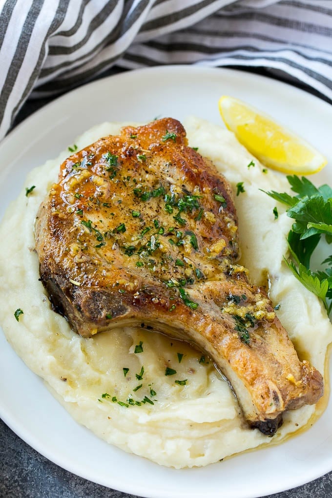 Brown Sugar Pork Chops Recipe | Bone In Pork Chops Recipe | Garlic Butter Pork Chops | Skillet Pork Chops #pork #porkchops #garlic #dinner #glutenfree #ezlod Brown sugar pork chops on a bed of mashed potatoes.