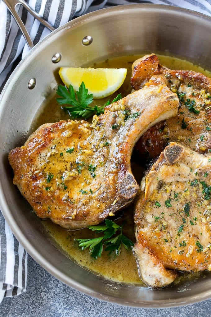 Brown Sugar Pork Chops Recipe | Bone In Pork Chops Recipe | Garlic Butter Pork Chops | Skillet Pork Chops #pork #porkchops #garlic #dinner #glutenfree #ezlod Brown sugar pork chops with garlic, butter and herbs in a frying pan.