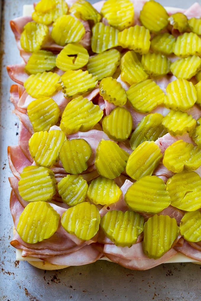 Cuban Sliders Recipe | Cuban Sandwich Recipe | Slider Sandwiches | Ham and Cheese Sliders #sliders #sandwiches #ham #cheese #appetizer #ezlod Bread layered with cheese, ham and pickles.