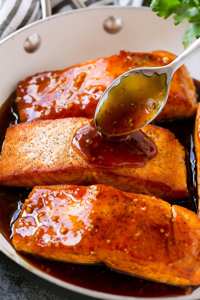Honey Garlic Salmon Recipe | Asian Salmon Recipe | Healthy Salmon Recipe #salmon #fish #seafood #healthy #dinner #ezlod A spoon pouring sauce on top of salmon fillets.
