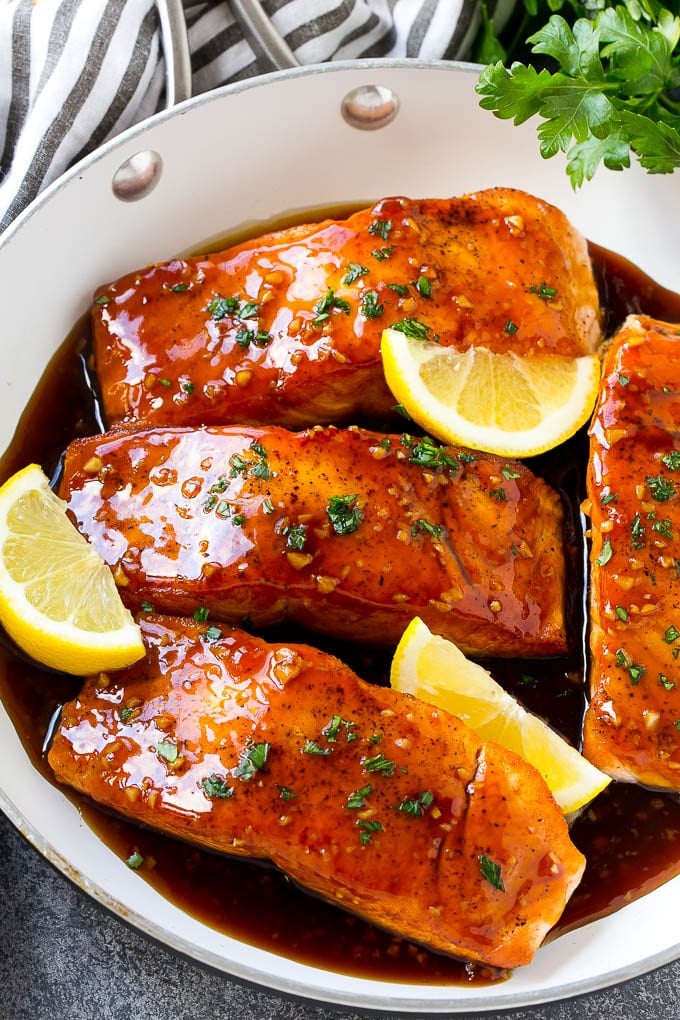 Honey Garlic Salmon Recipe | Asian Salmon Recipe | Healthy Salmon Recipe #salmon #fish #seafood #healthy #dinner #ezlod A pan of honey garlic salmon topped with a savory sauce and garnished with parsley and lemon.