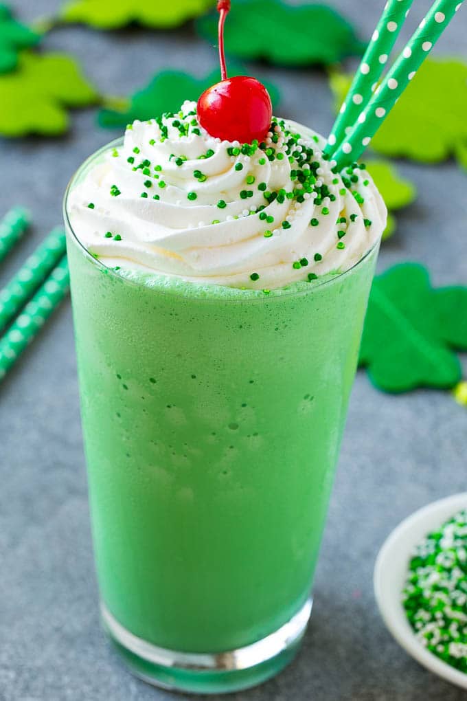 Shamrock Shake Recipe | McDonald's Shamrock Shake | Saint Patrick's Day Drink | Mint Milkshake #milkshake #stpatricksday #saintpatricksday #mint #ezlod A glass of shamrock shake topped with whipped cream, sprinkles and a cherry.