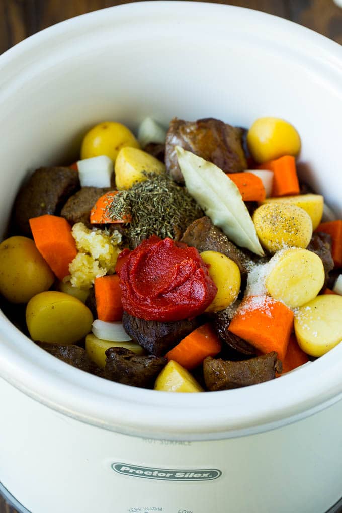 Slow Cooker Beef Stew Recipe | Crockpot Beef Stew #stew #soup #beef #slowcooker #crockpot #dinner #ezlod A crock pot filled with beef, vegetables, tomato paste, herbs and spices.