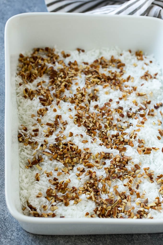 Earthquake Cake Recipe | Chocolate Cake Recipe | Chocolate Coconut Cake | Coconut Pecan Cake #cake #chocolate #coconut #pecans #dessert #chocolatecake #ezlod Coconut and pecans layered into a cake pan.