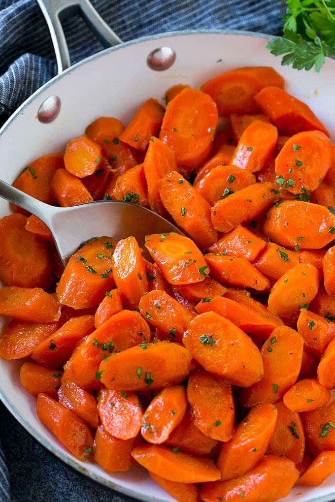 Candied Carrots Recipe | Carrot Side Dish | Brown Sugar Carrots | Glazed Carrots #carrots #brownsugar #sidedish #dinner #ezlod Candied carrots in a pan with a serving spoon.