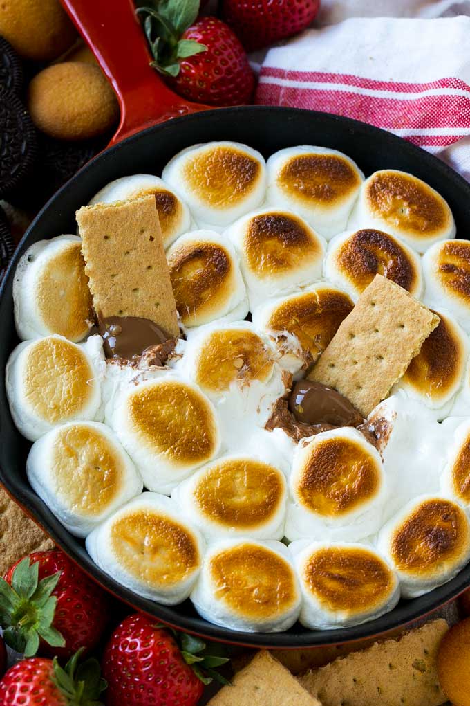S'mores Dip Recipe | S'mores Skillet | Baked S'mores #smores #dip #chocolate #marshmallow #dessert #ezlod A skillet of s'mores dip with melted milk chocolate topped with toasted marshmallows.