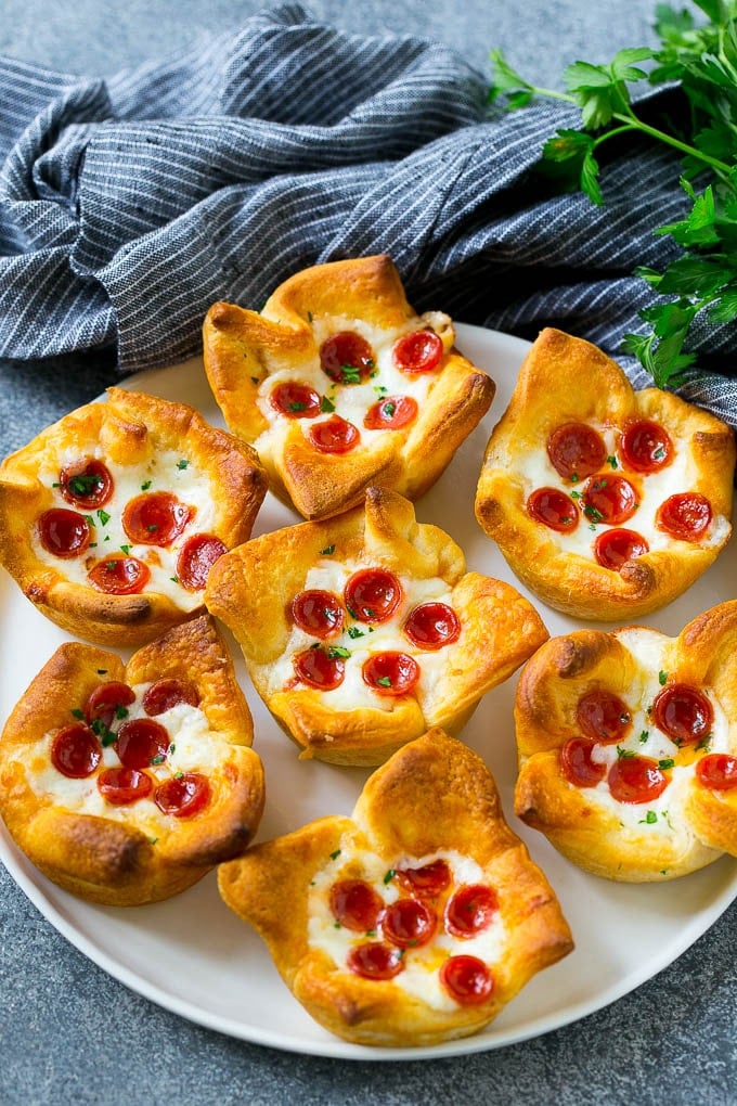 Pizza Muffins Recipe | Pizza Bites | Pizza Cups | Pizza Appetizer #pizza #appetizer #ezlod Pizza muffins on a serving plate garnished with parsley.