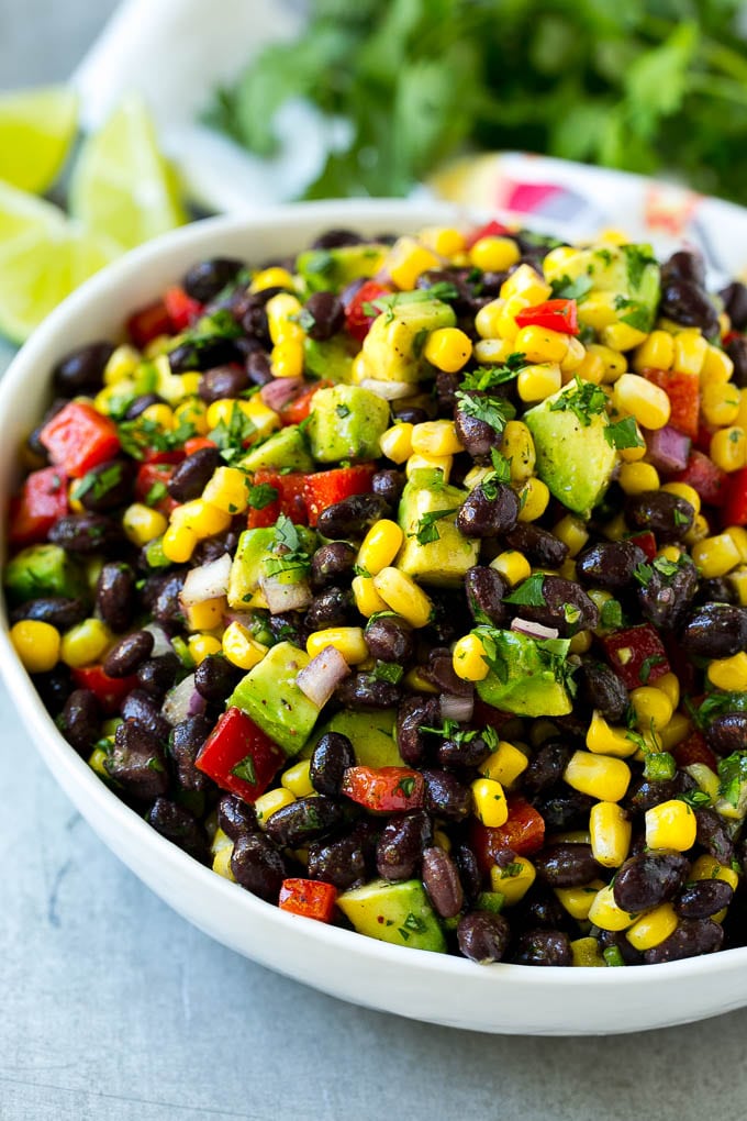 Black Bean and Corn Salad Recipe | Mexican Salad | Black Bean Salad | Bean Salad #salad #beans #corn #mexicanfood #ezlod A bowl of black bean and corn salad loaded with avocado and red pepper, garnished with fresh cilantro.
