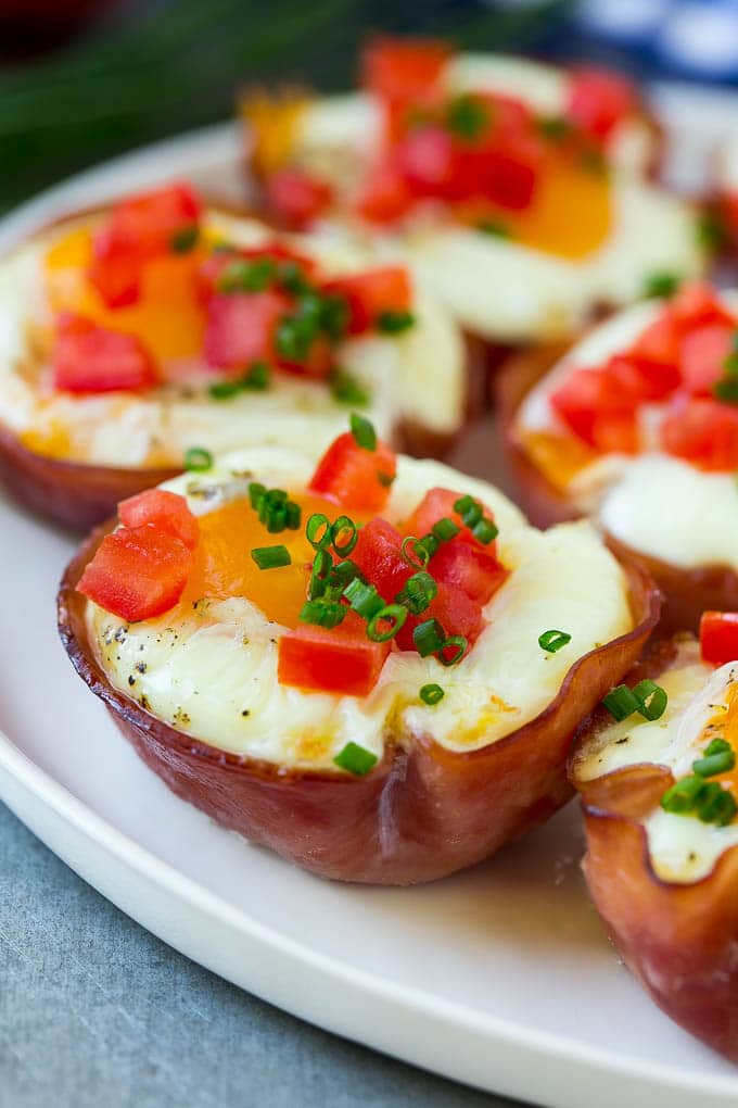 Ham and Egg Cups Recipe | Low Carb Breakfast | Ham and Eggs #ham #eggs #lowcarb #breakfast #ezlod A plate of ham and egg cups topped with diced tomatoes and chives.