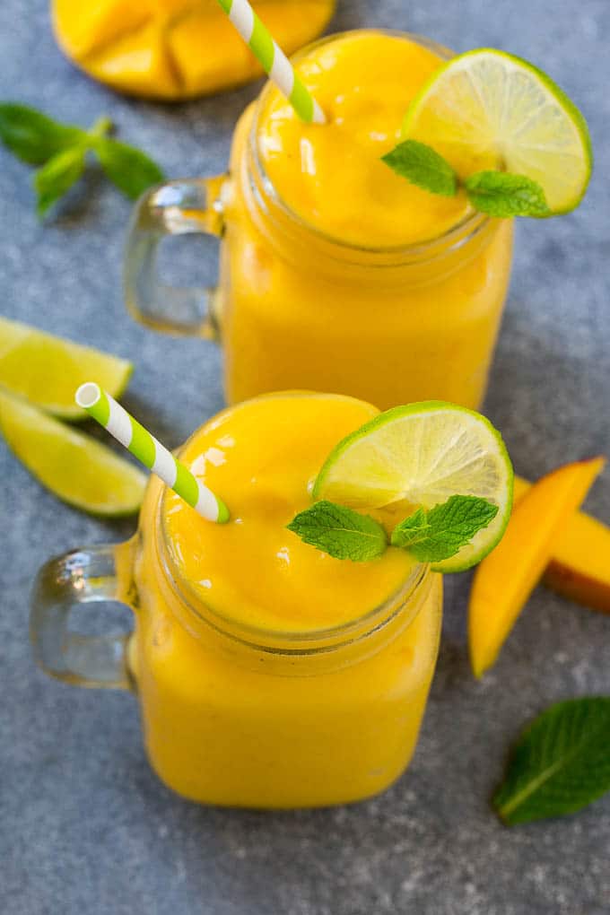 Mango Smoothie Recipe | Mango Recipe | Healthy Smoothie #mango #smoothie #drink #ezlod Two jars full of mango smoothie, garnished with lime slices and fresh mint.