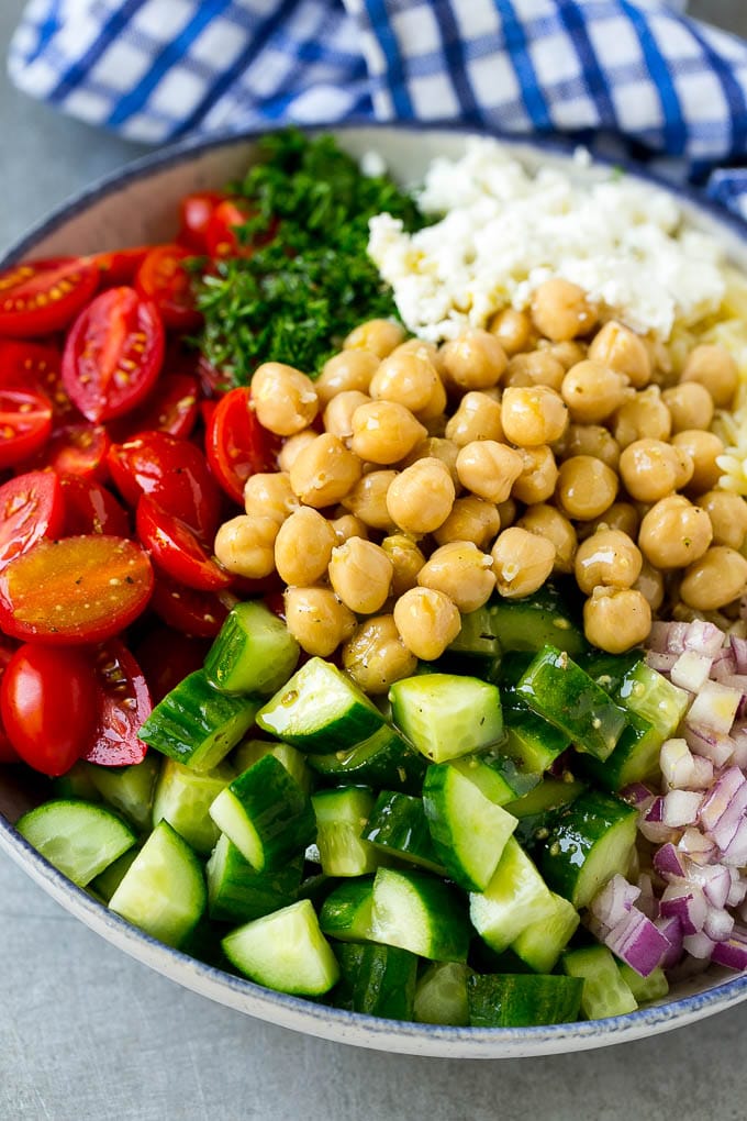 Orzo Salad Recipe | Orzo Pasta Salad | Greek Orzo Salad | Mediterranean Orzo Salad #pastasalad #orzo #greekfood #salad #ezlod A bowl of orzo pasta, tomatoes, cucumbers, red onions, chickpeas and feta cheese topped with dressing.