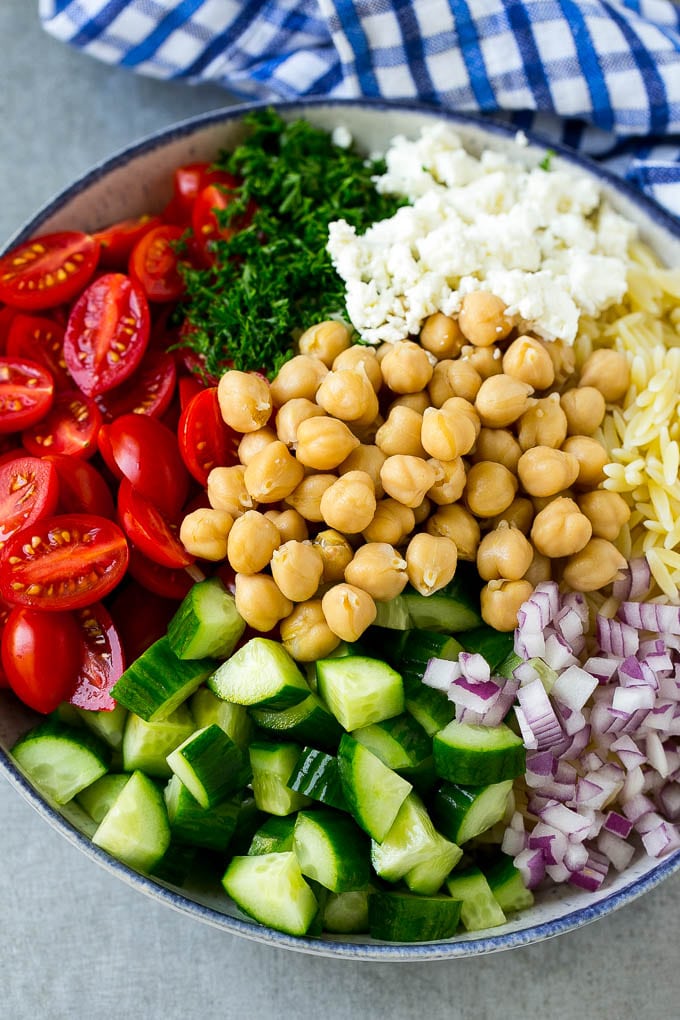 Orzo Salad Recipe | Orzo Pasta Salad | Greek Orzo Salad | Mediterranean Orzo Salad #pastasalad #orzo #greekfood #salad #ezlod A bowl of orzo pasta, cucumbers, cherry tomatoes, feta cheese, red onions, herbs and chickpeas.