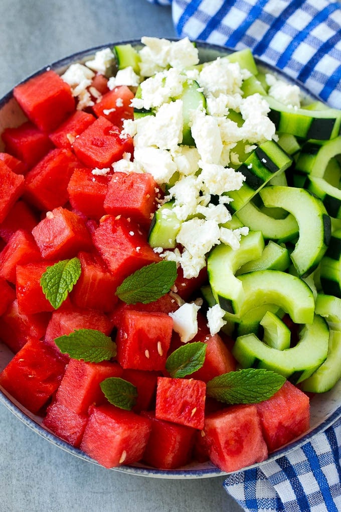 Watermelon Salad Recipe | Watermelon Feta Salad | Watermelon Cucumber Salad #watermelon #cucumber #salad #ezlod A bowl of cubed watermelon, sliced cucumbers, feta cheese and mint leaves.