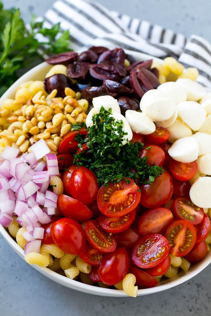 Pesto Pasta Salad | Italian Pasta Salad | Easy Pasta Salad #pasta #salad #pesto #olives #tomatoes #ezlod Pasta with cherry tomatoes, mozzarella balls, kalamata olives, parsley and red onion.