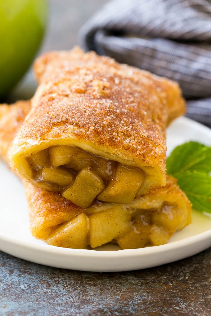 Fried Apple Pies Recipe | McDonald's Copycat Recipe | Apple Pie | Apple Hand Pies #pie #apples #applepie #dessert #snack #ezlod A cross section of a fried apple pie on a plate.