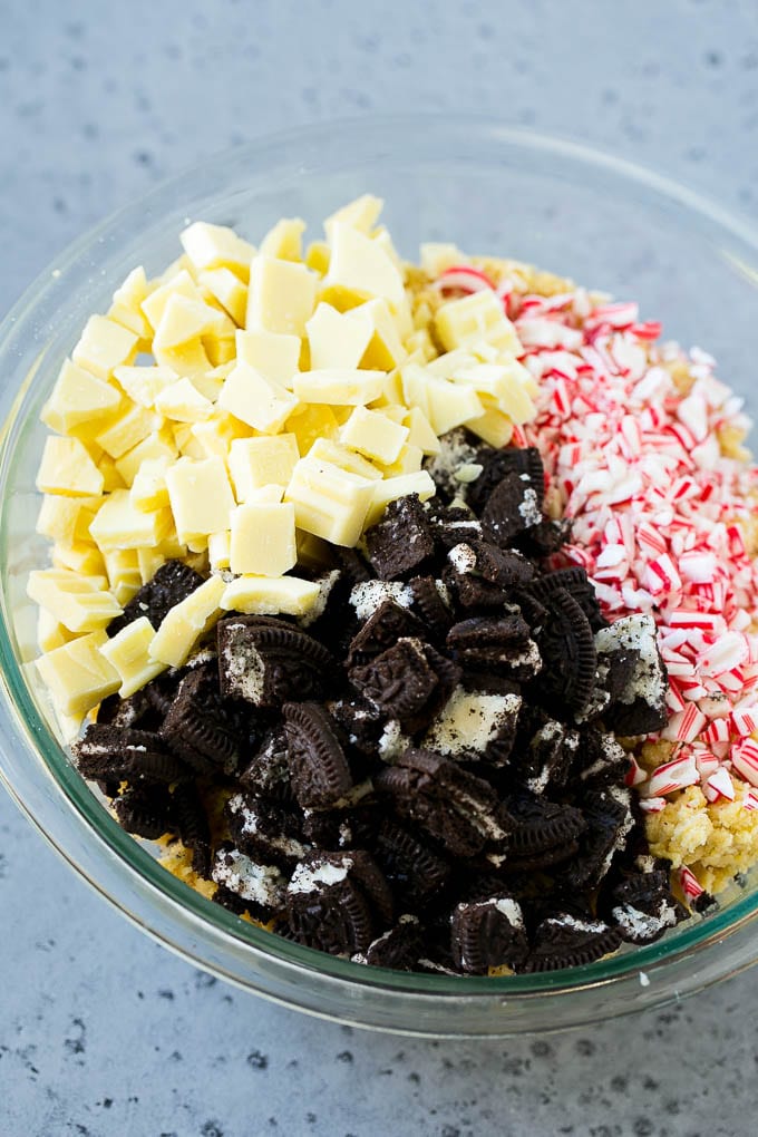Oreo Peppermint Cookies Recipe | Candy Cane Cookies | Oreo Cookies #oreo #peppermint #cookies #baking #Christmas #sweets #ezlod A bowl of dough with Oreo pieces, white chocolate chunks and crushed candy canes.