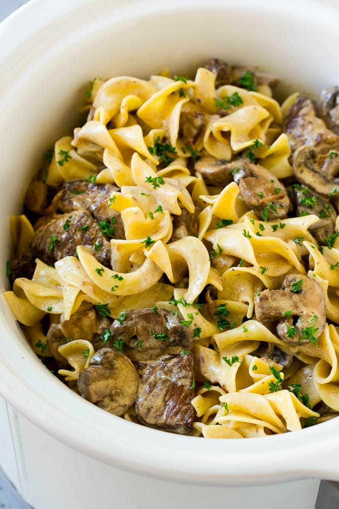 Slow Cooker Beef Stroganoff Recipe | Crock Pot Beef Stroganoff | Beef Recipe #slowcooker #crockpot #beef #mushrooms #pasta #dinner #ezlod Slow cooker beef stroganoff with chunks of beef, mushrooms and egg noodles topped with parsley.