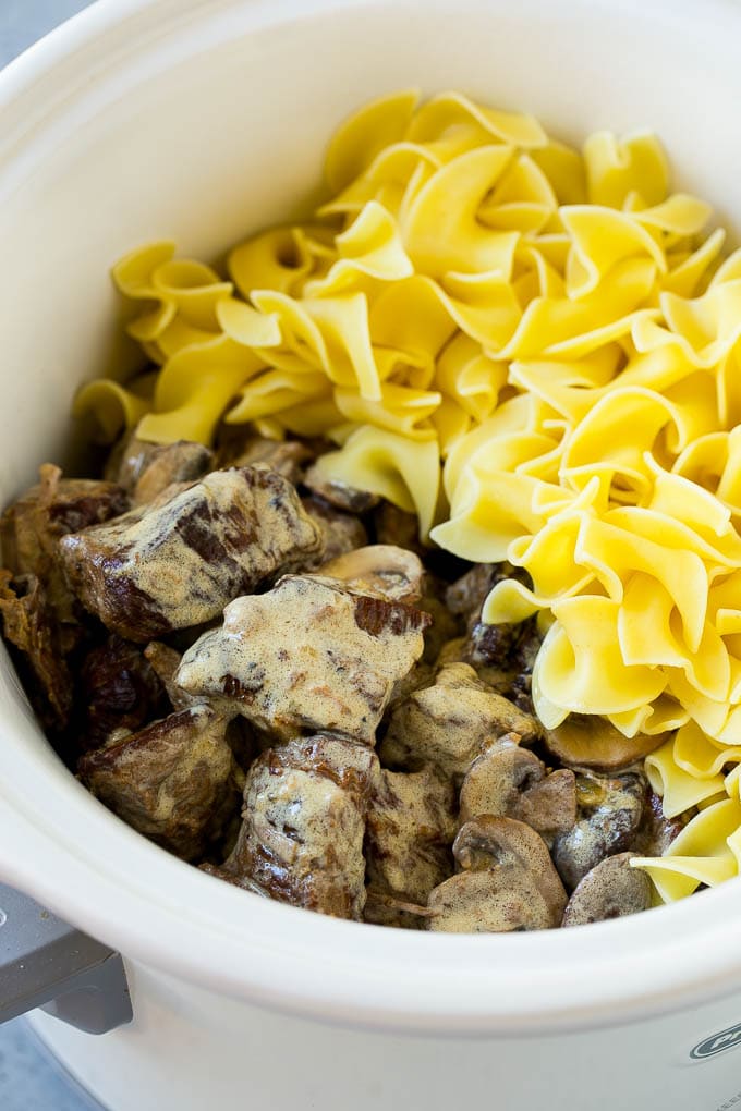 Slow Cooker Beef Stroganoff Recipe | Crock Pot Beef Stroganoff | Beef Recipe #slowcooker #crockpot #beef #mushrooms #pasta #dinner #ezlod Beef in a creamy sauce and egg noodles in a slow cooker.