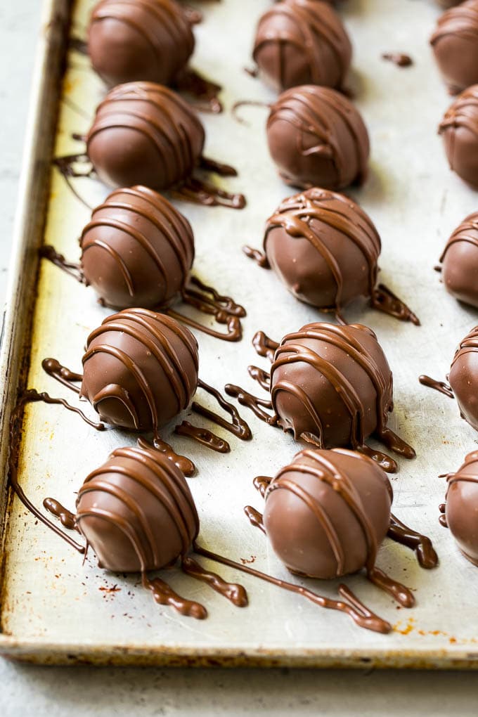 Chocolate Covered Cherries Recipe | Cherry Cordials | Cherry Candy #chocolate #candy #dessert #cherry #sweets #ezlod Chocolate covered cherries on a sheet pan with a chocolate drizzle on top.