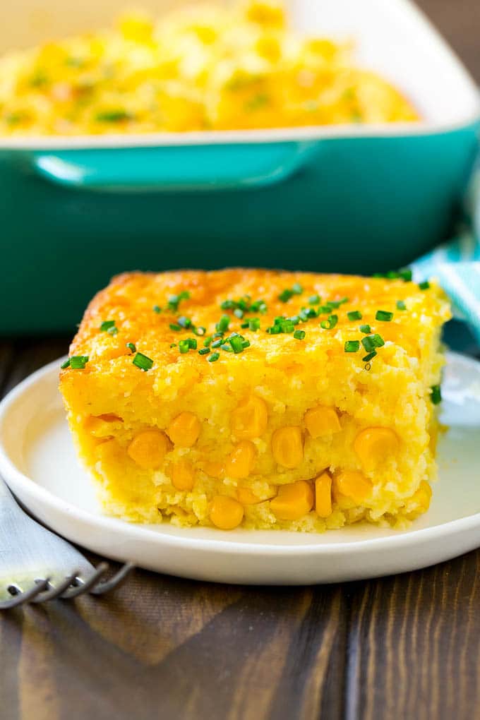 Corn Pudding Recipe | Corn Casserole | Corn Side Dish #corn #pudding #casserole #sidedish #thanksgiving #dinner #ezlod A serving of corn pudding on a plate, garnished with chives.