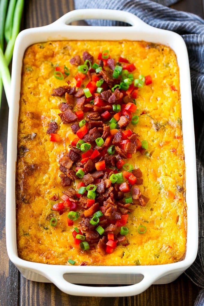 Loaded Corn Casserole Recipe | Easy Corn Casserole | Bacon Corn Casserole | Corn Pudding #corn #casserole #bacon #cheese #sidedish #thanksgiving #dinner #ezlod A casserole of loaded corn casserole topped with bacon, red peppers and green onions.