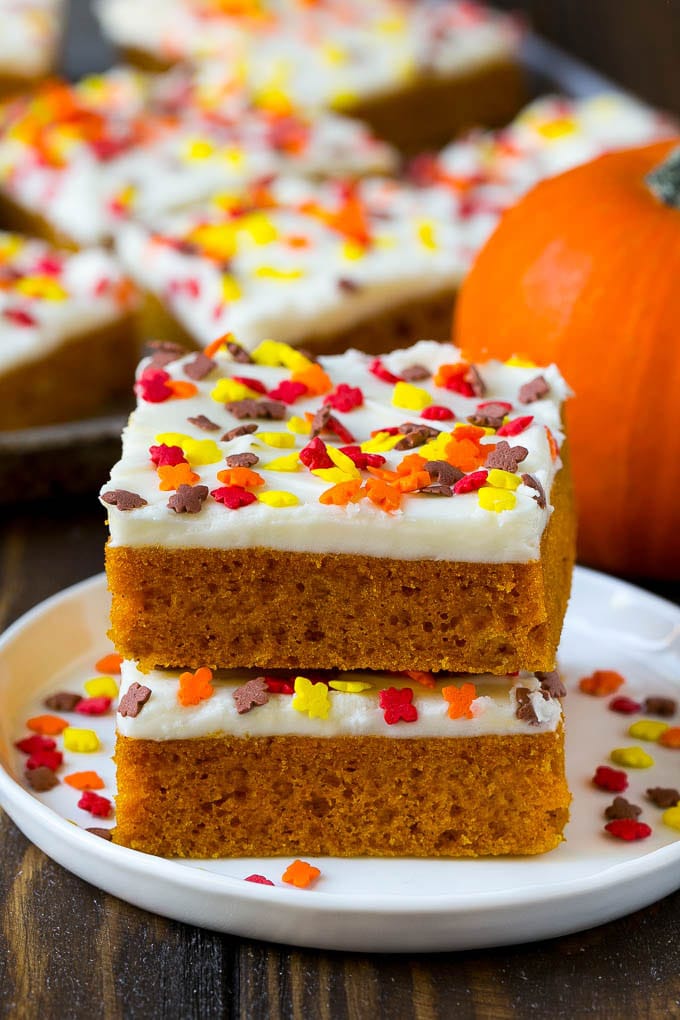 Pumpkin Bars Recipe | Pumpkin Cake | Pumpkin Dessert #pumpkin #fall #dessert #ezlod #thanksgiving A stack of pumpkin bars topped with frosting and sprinkles.
