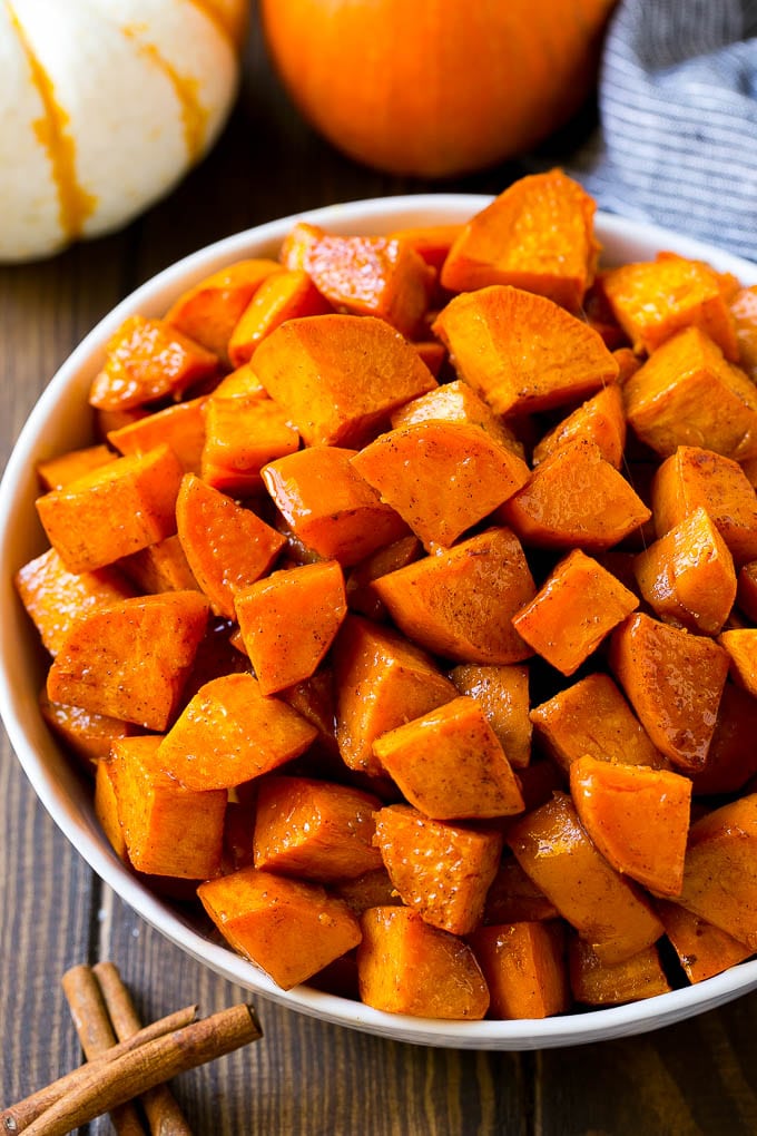 Maple Roasted Sweet Potatoes Recipe | Easy Sweet Potatoes | Baked Sweet Potatoes | Sweet Potato Side Dish #sweetpotatoes #cinnamon #maple #butter #fall #sidedish #dinner #ezlod A bowl of maple roasted sweet potatoes with cinnamon and butter on top.