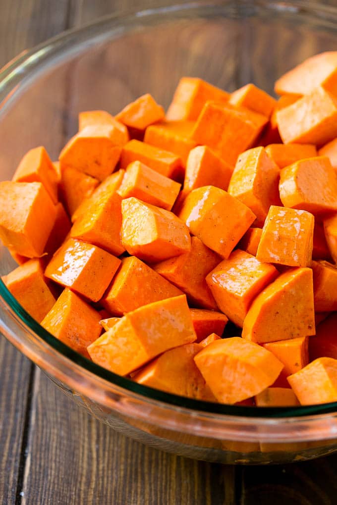 Maple Roasted Sweet Potatoes Recipe | Easy Sweet Potatoes | Baked Sweet Potatoes | Sweet Potato Side Dish #sweetpotatoes #cinnamon #maple #butter #fall #sidedish #dinner #ezlod A bowl of peeled and diced yams.