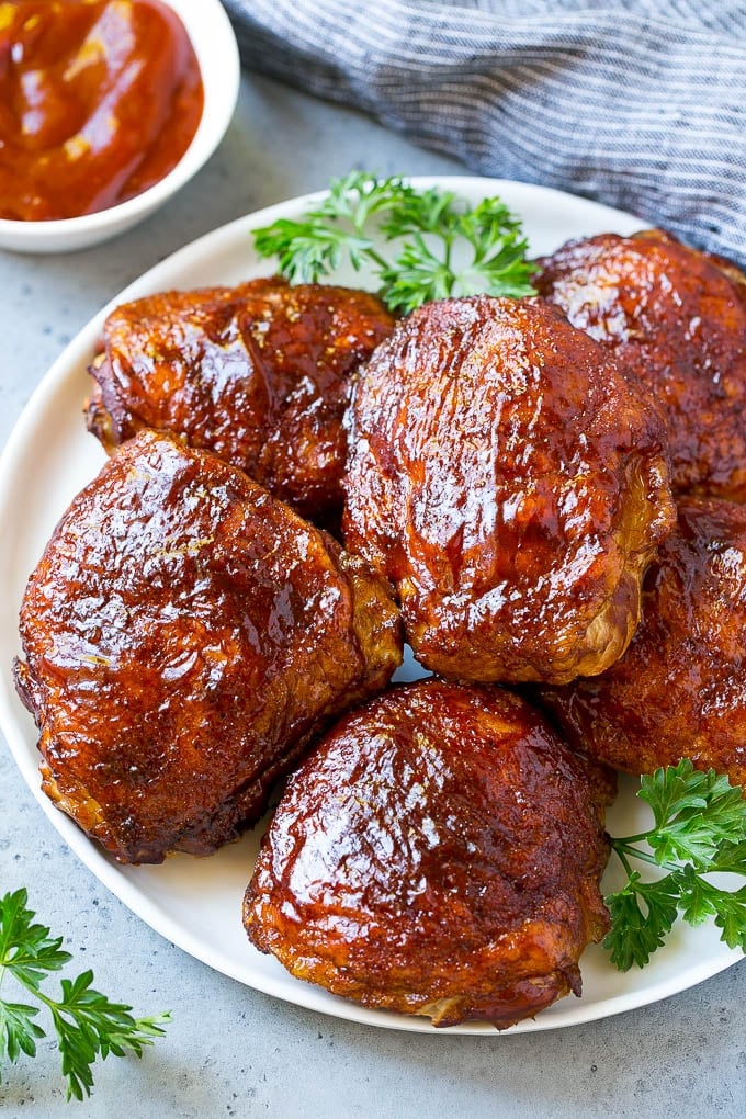Smoked Chicken Thighs Recipe | Barbecue Chicken Thighs | Easy Chicken Thighs #chicken #barbecue #smoker #dinner #ezlod A plate of smoked chicken thighs coated in spice rub and barbecue sauce.