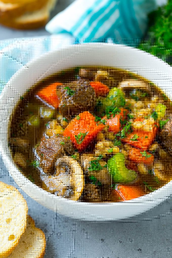 Beef Barley Soup Recipe | Beef Soup | Barley Soup #soup #beef #dinner #vegetables #ezlod #comfortfood A bowl of beef barley soup topped with chopped parsley.