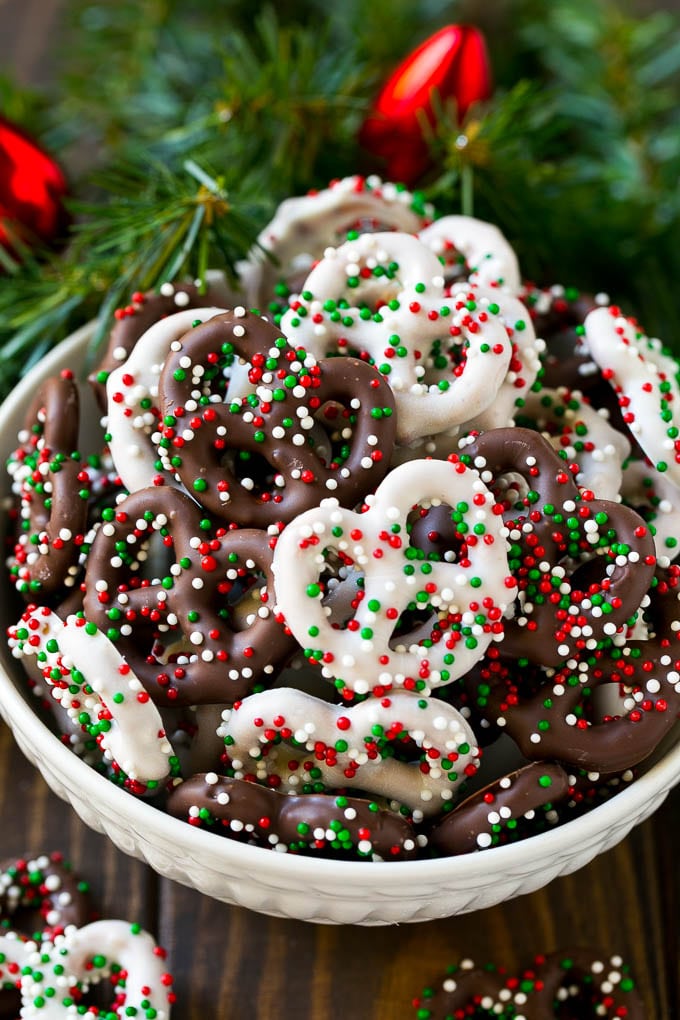 Chocolate Covered Pretzels Recipe | Sprinkle Pretzels | No Bake Dessert #pretzels #chocolate #christmas #sprinkles #candy #ezlod Chocolate covered pretzels in a bowl with Christmas sprinkles.