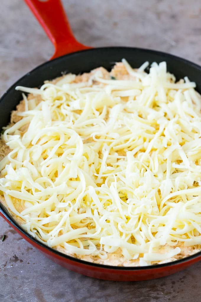 Crab Dip Recipe | Hot Crab Dip | Seafood Dip #dip #crab #seafood #appetizer #ezlod #cheese Shredded Monterey Jack cheese sprinkled over a skillet of mixture.