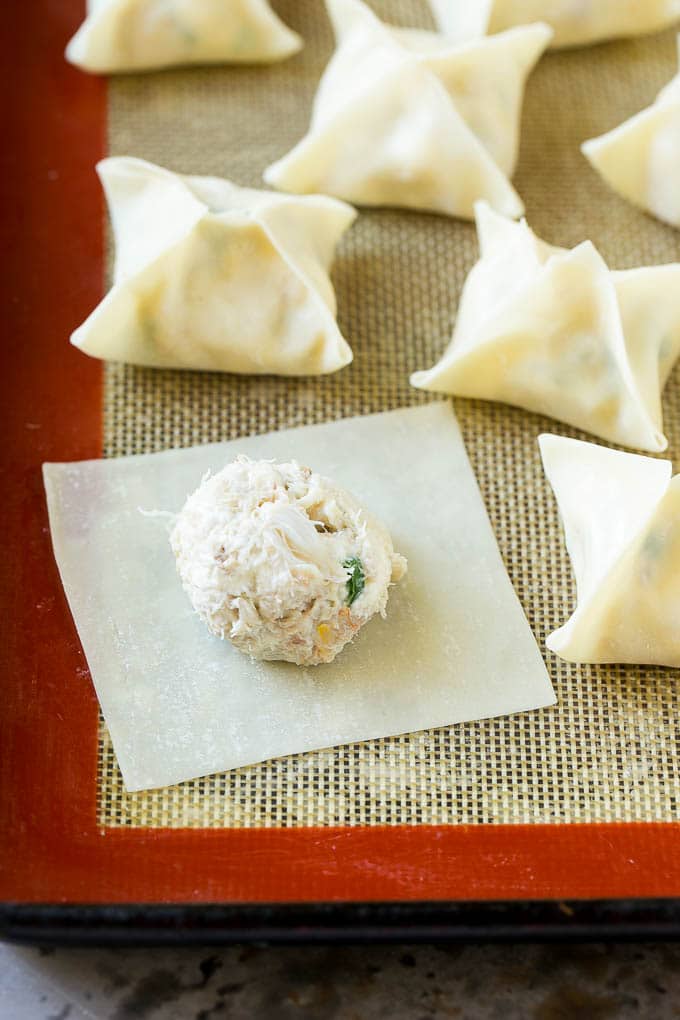 Crab Rangoon Recipe | Crab Wontons | Cream Cheese Wontons #crab #cheese #appetizer #snack #chinesefood #dinner #ezlod A wonton wrapper with a dollop of filling on it.