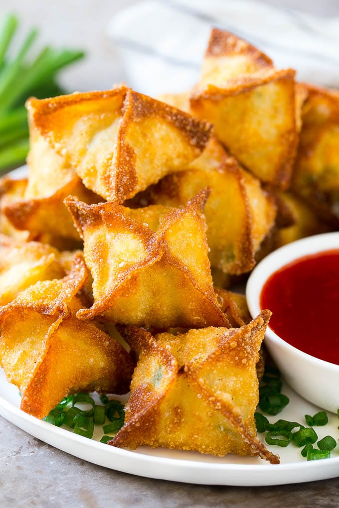 Crab Rangoon Recipe | Crab Wontons | Cream Cheese Wontons #crab #cheese #appetizer #snack #chinesefood #dinner #ezlod A pile of crab rangoon wontons filled with a creamy crab mixture.