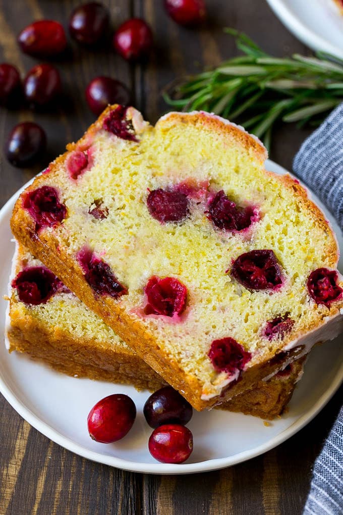 Cranberry Bread Recipe | Cranberry Loaf | Cranberry Orange Bread #cranberry #bread #baking #dessert #fall #ezlod A plate with two slices of cranberry bread and fresh cranberries for garnish.