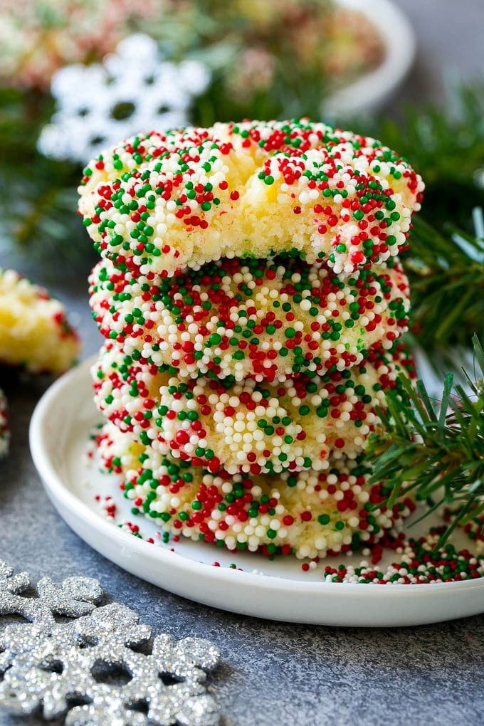 Gooey Butter Cookies Recipe | Cake Mix Cookies | Sprinkle Cookies | Christmas Cookies #cookies #butter #sprinkles #christmas #dessert #baking #ezlod A stack of gooey butter cookies with a bite taken out of one.
