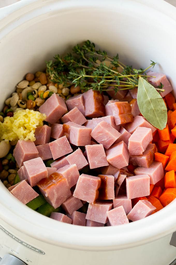 Ham and Bean Soup Recipe | Slow Cooker Ham and Bean Soup | Crockpot Ham and Bean Soup | Leftover Ham Recipe #ham #beans #soup #slowcooker #crockpot #dinner #ezlod Vegetables, pork, herbs and garlic in the slow cooker.