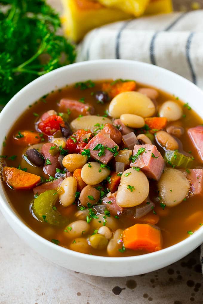 Ham and Bean Soup Recipe | Slow Cooker Ham and Bean Soup | Crockpot Ham and Bean Soup | Leftover Ham Recipe #ham #beans #soup #slowcooker #crockpot #dinner #ezlod A bowl of ham and bean soup made with dried beans, ham and vegetables, then topped with fresh parsley.