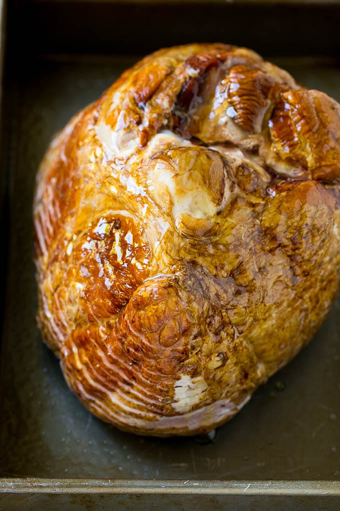 Honey Baked Ham Recipe | Glazed Ham | Holiday Ham #ham #dinner #ezlod #christmas #thanksgiving #easter A honey coated ham, face down, in a baking dish.