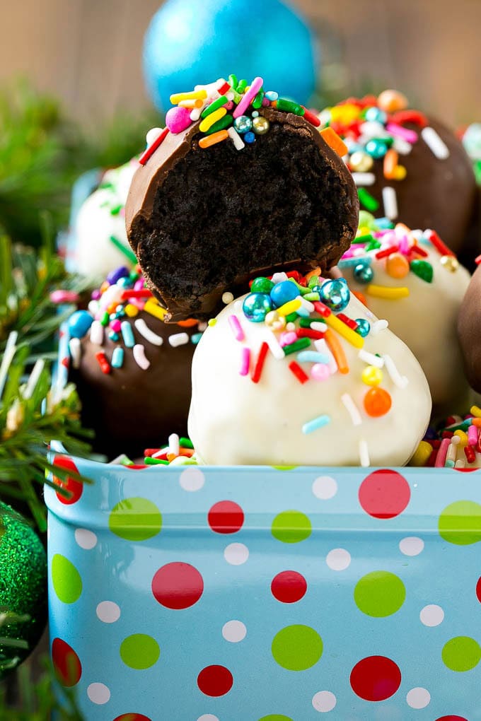 Oreo Balls Recipe | Oreo Truffles | Homemade Candy #truffles #candy #oreos #chocolate #sprinkles #dessert #christmas #ezlod A cross section of an Oreo ball inside a holiday gift tin.